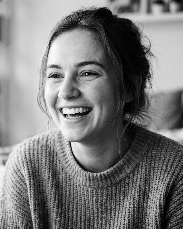 A creator laughing as she films herself on her phone